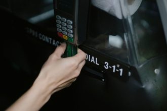 Pessoa paga uma corrida de táxi aproximando um cartão de um dispositivo de pagamento dentro do veículo.