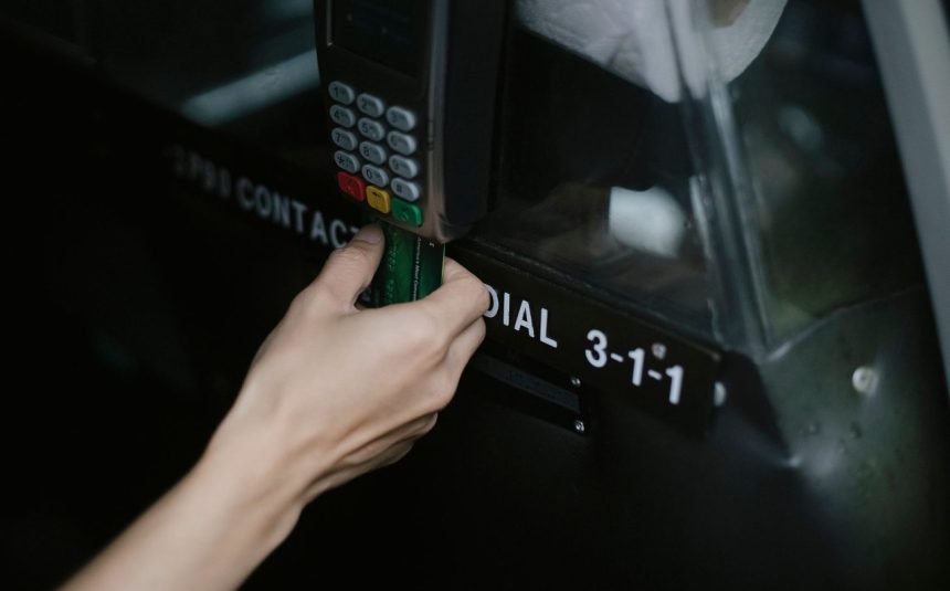 Pessoa paga uma corrida de táxi aproximando um cartão de um dispositivo de pagamento dentro do veículo.