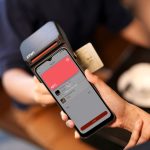 Smartphone sendo aproximado de um terminal para realizar pagamento por aproximação via NFC