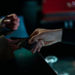 Mãos trocando ingressos de cinema em um ambiente interno