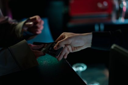 Mãos trocando ingressos de cinema em um ambiente interno