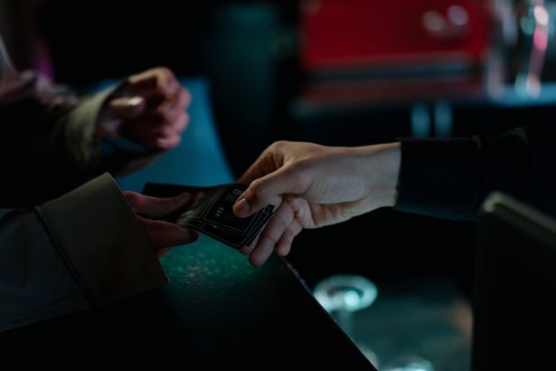 Mãos trocando ingressos de cinema em um ambiente interno